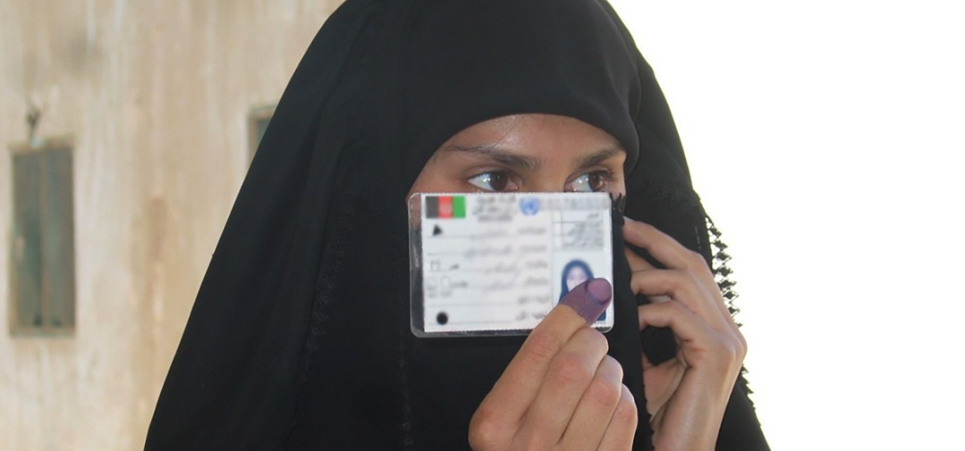 iraqi woman holds her voter registration card