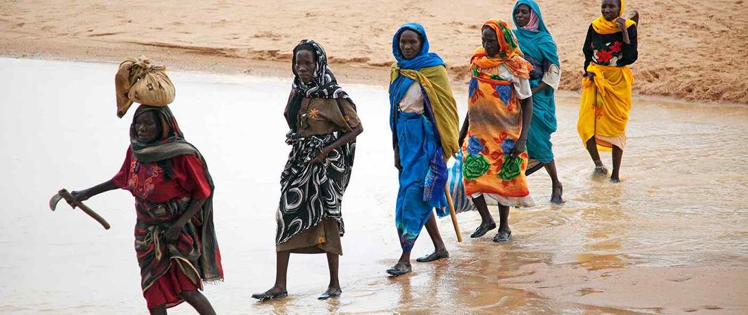 Women walking across a river