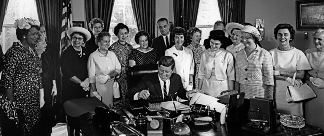 Women standing behind JFK