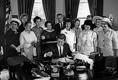 Women standing behind JFK