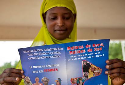 A young woman reads the official informational flyer of the Peace Caravan in Gao, Mali. August, 2013. UN Photo/Marco Dormino.